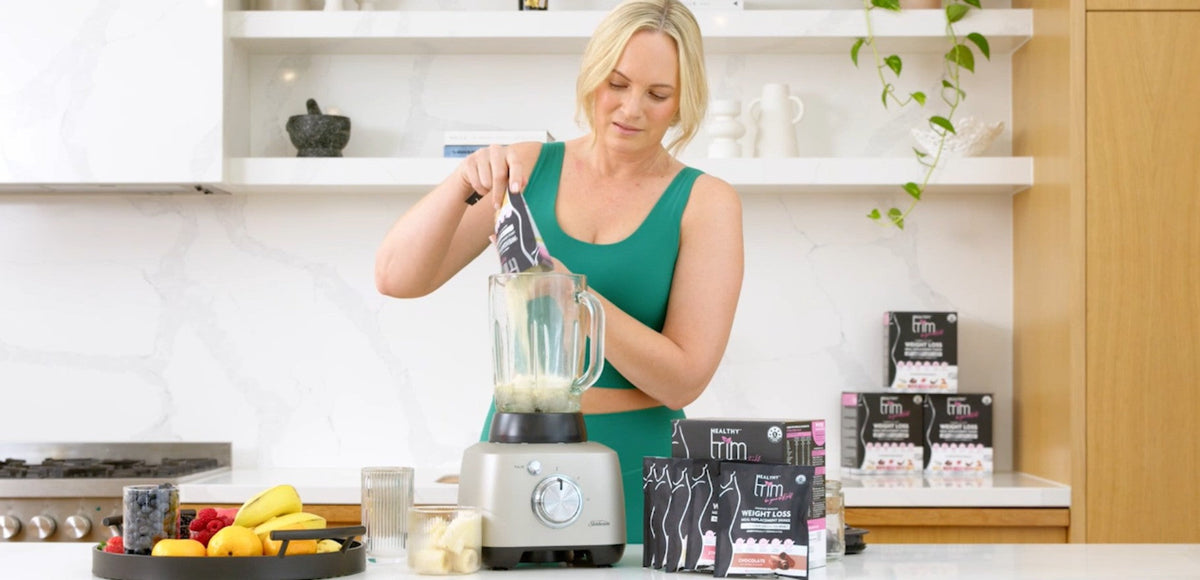 Lady pouring Healthy Trim powder in blender.