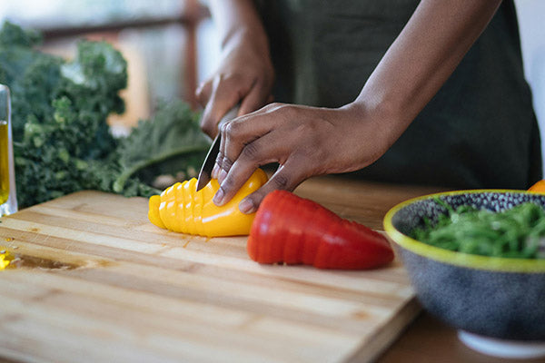Lady cutting capsicum for her snack.